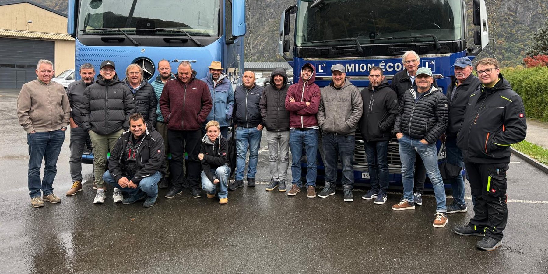 Volée de chauffeurs professionnels en formation continue OACP devant deux camions, dont un 100 % électrique