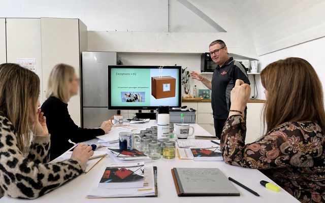 Formateur et participantes autour d'échantillons de produits dangereux en salle